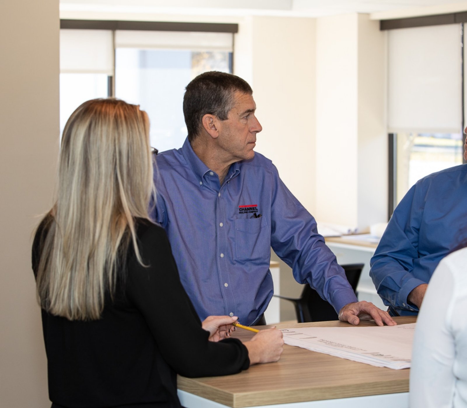 3 people talking at a work table